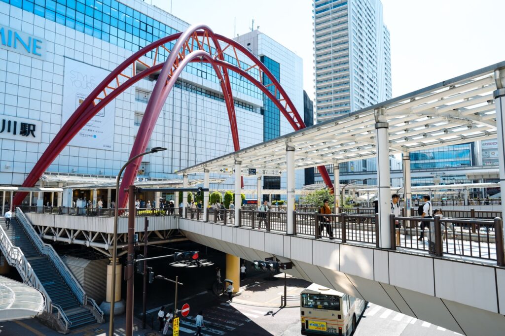 立川駅北口の大きな赤いアーチ状モニュメントと歩行者デッキ