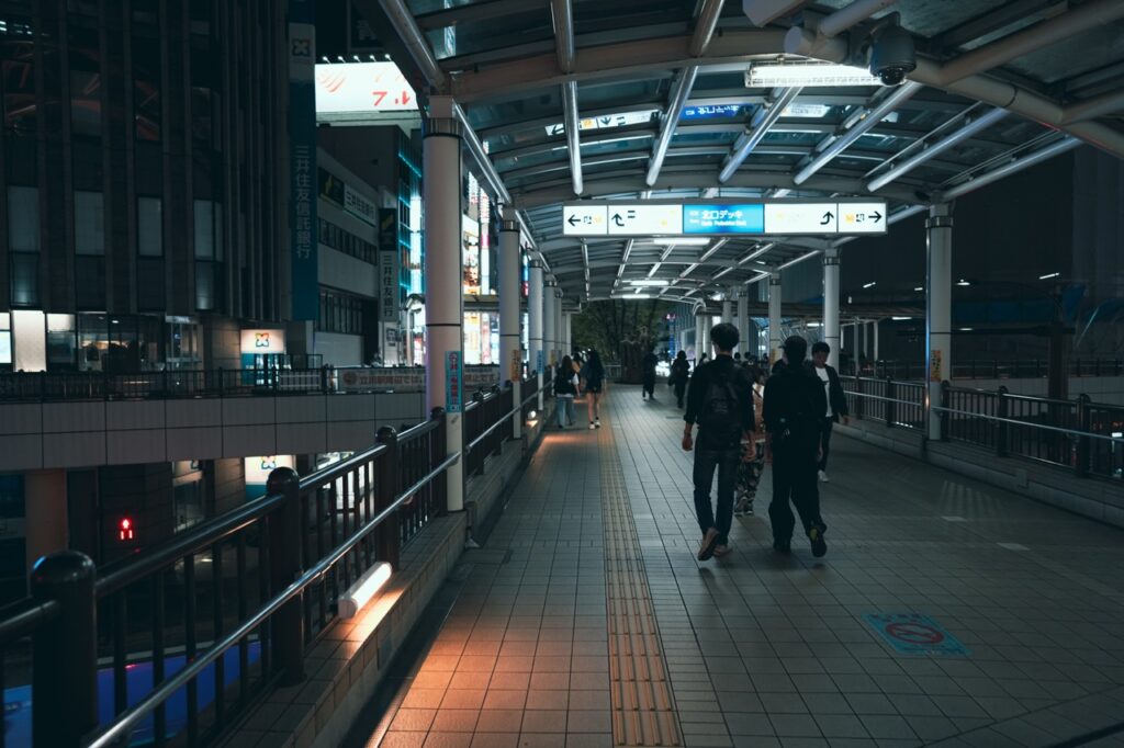 夜のペデストリアンデッキを歩く人々