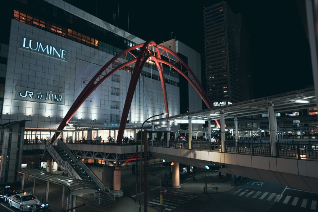 赤いアーチ構造と夜の駅ビル